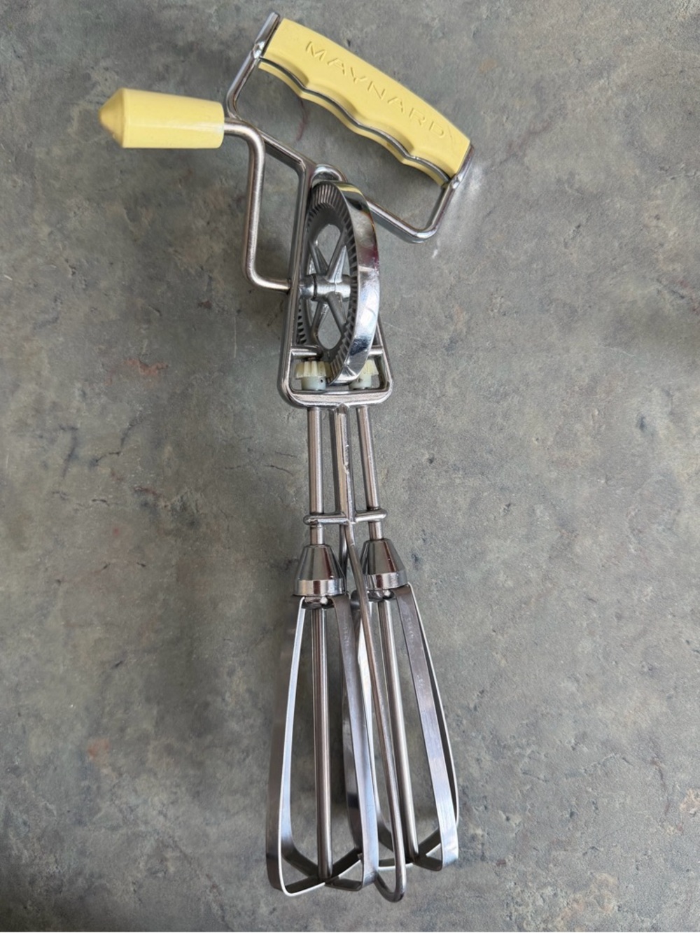 vintage Maynard hand crank egg beater with a yellow handle